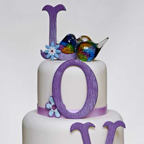Love wedding cake with lovebirds on top